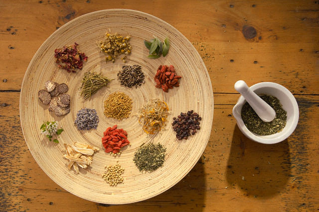 Assorted medicinal herbs and spices with a mortar and pestle --- Image by © Peter Frank/Corbis